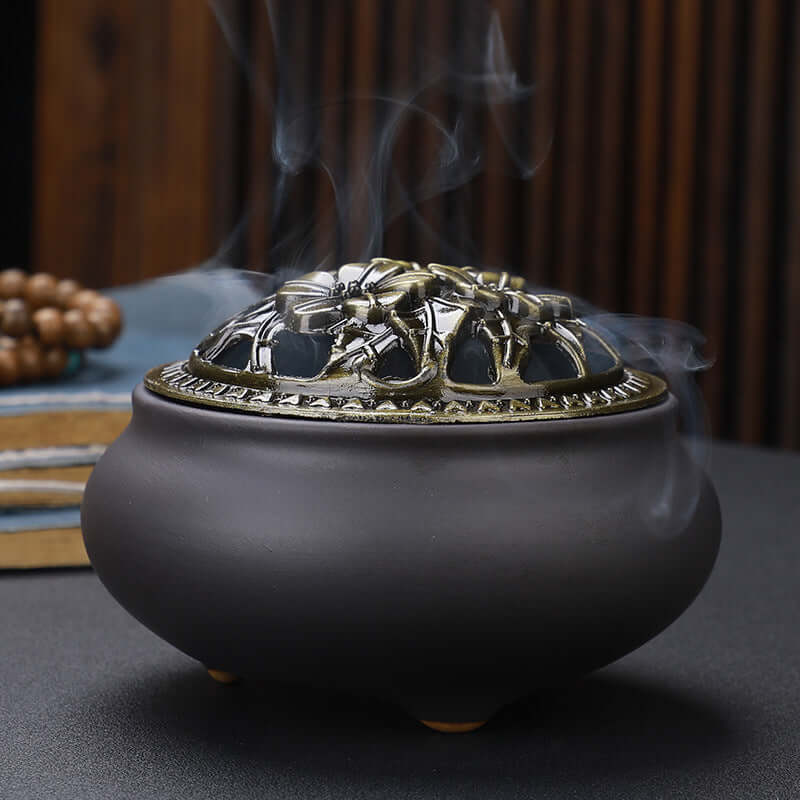 Ceramic Buddha Incense Burner with antique copper lid and smoke, perfect for meditation and calming spaces.