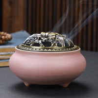 Ceramic Buddha Incense Burner with antique copper lid and smoke, perfect for meditation and calming spaces.