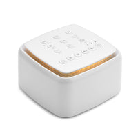 White noise machine placed beside a bed for nighttime use