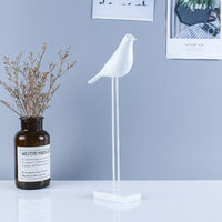 Modern minimalist white bird figurine on a slender metal stand