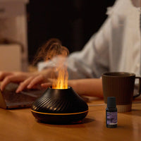 Flame Aroma Diffuser on a desk beside an essential oil bottle