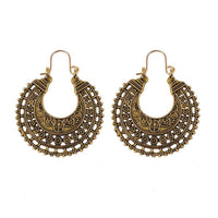 Gold mandala floral carved earring worn alongside model's hair