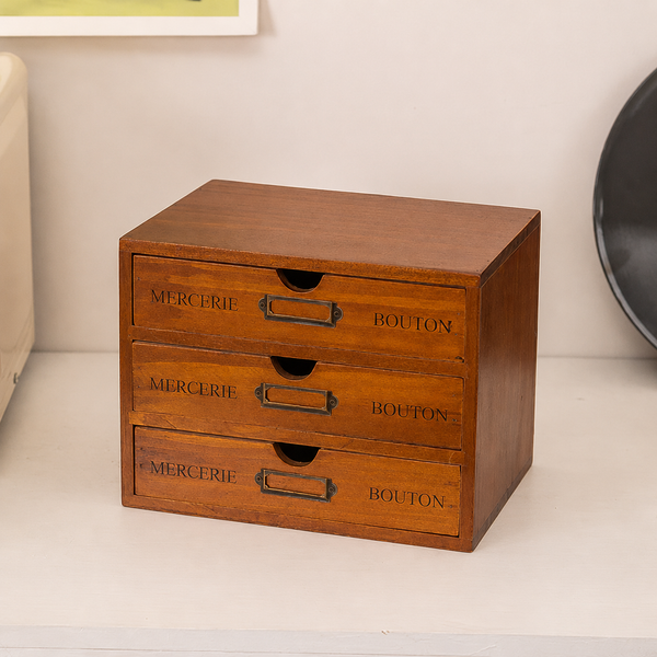 Vintage-style three-drawer wooden desk organizer with brass label holders, styled on a shelf