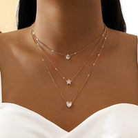 Layered Pendant Necklace Set in gold worn with heart and star charms