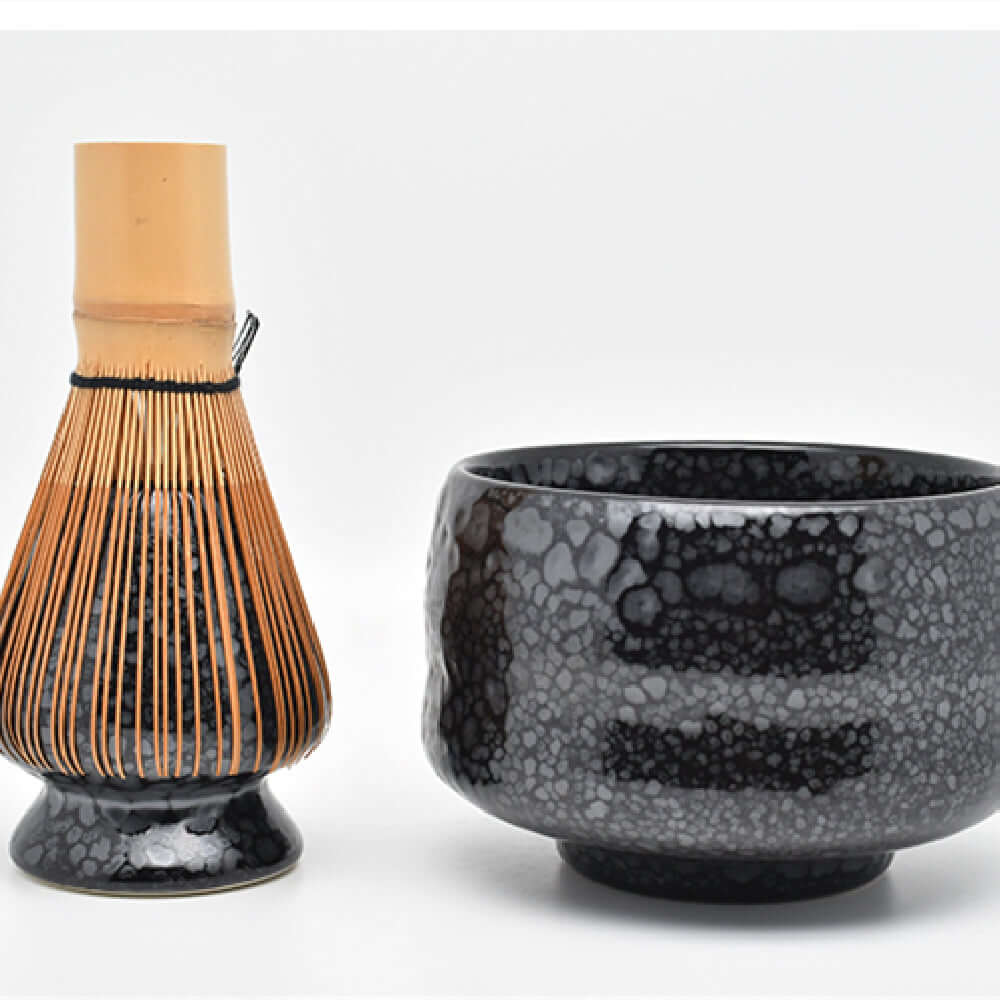 Tianmu oil drop matcha bowl with bamboo whisk in a Japanese glazed pottery tea set.